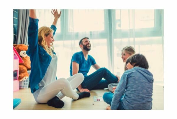 Famille jouant ensemble à un jeu de société, renforçant la communication et les liens familiaux.