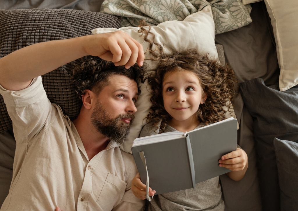 Rituel entre un père et sa fille partageant un moment de lecture, dans un climat serein et épanoui.