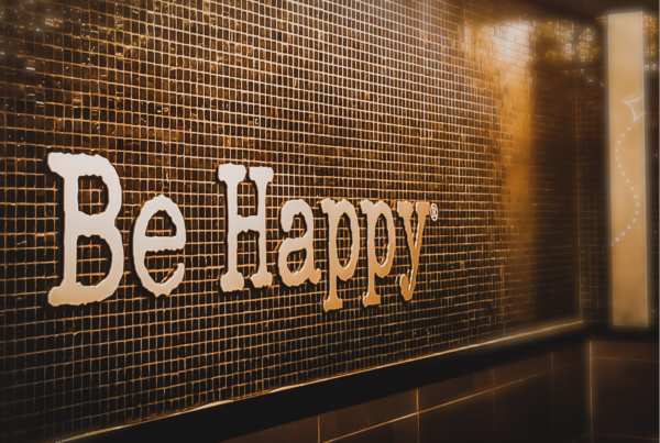 "Be happy" écrit sur un mur symbolise l'équilibre familial et l'importance de la gestion du bien-être au quotidien