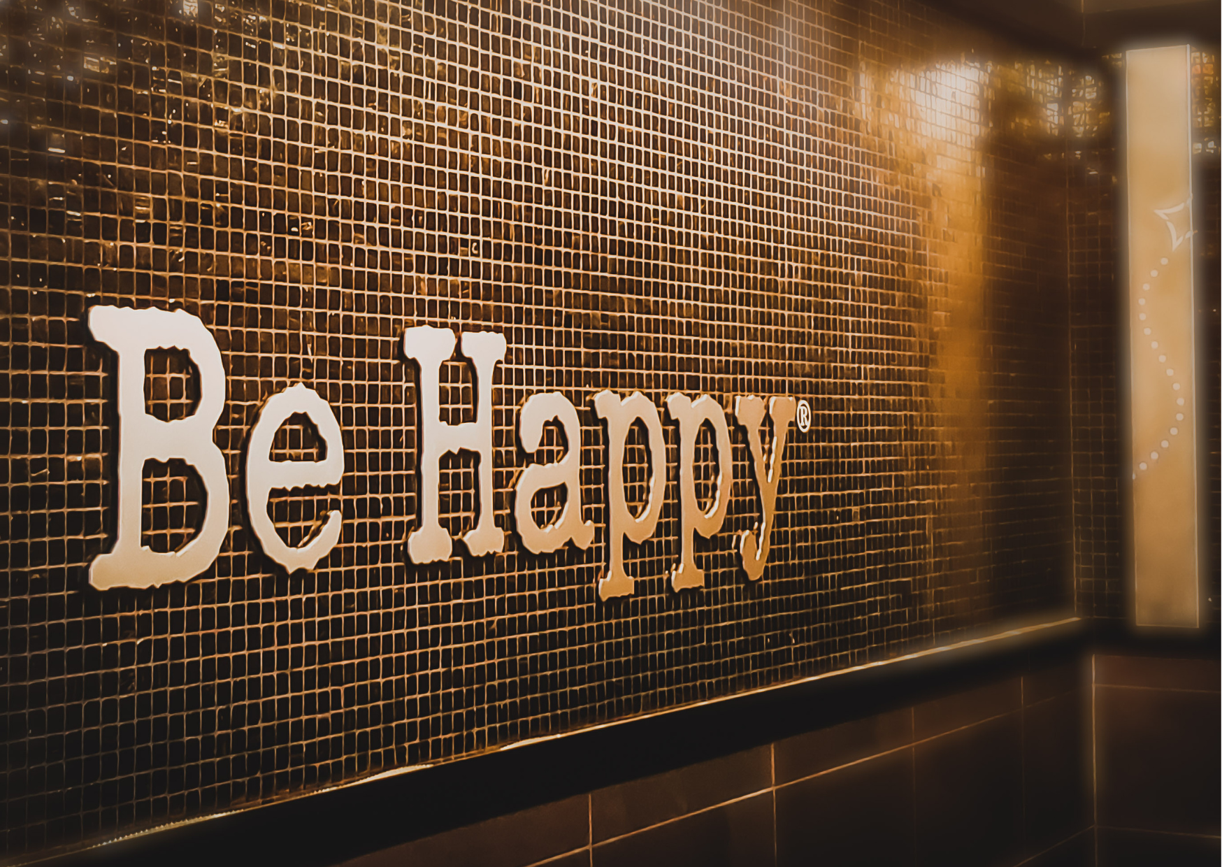 "Be happy" écrit sur un mur symbolise l'équilibre familial et l'importance de la gestion du bien-être au quotidien